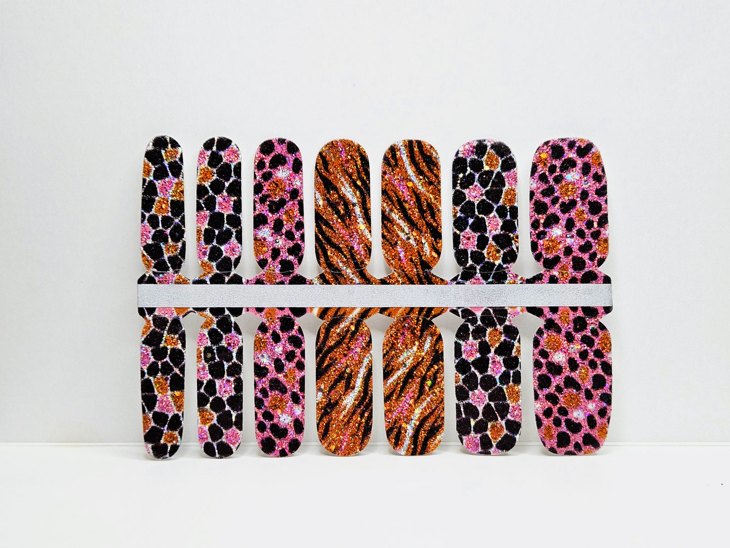 Set of nail wraps with pink and black glitter animal print designs against a white background