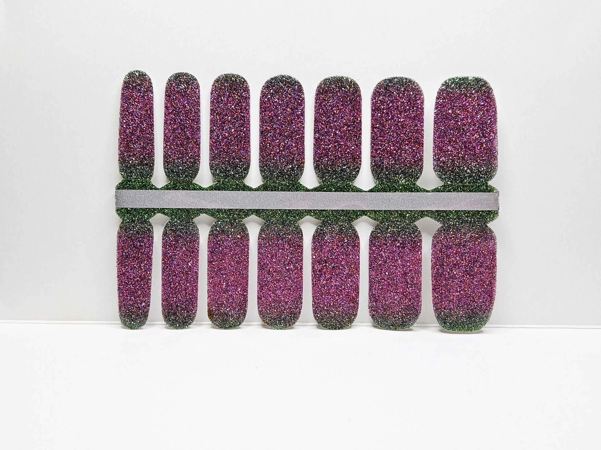 Pink glittery nail wraps  against  a white background