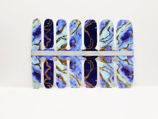 Set of blue and gold marbled nail wraps on a white background