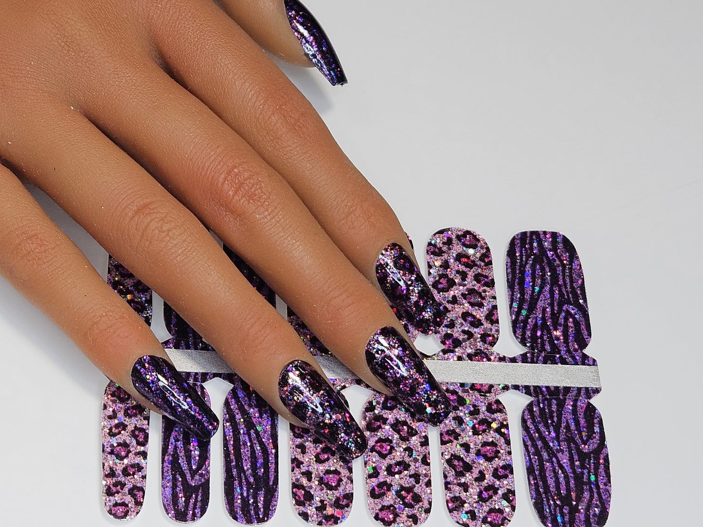 Purple and black glittery nail wrap on a white background