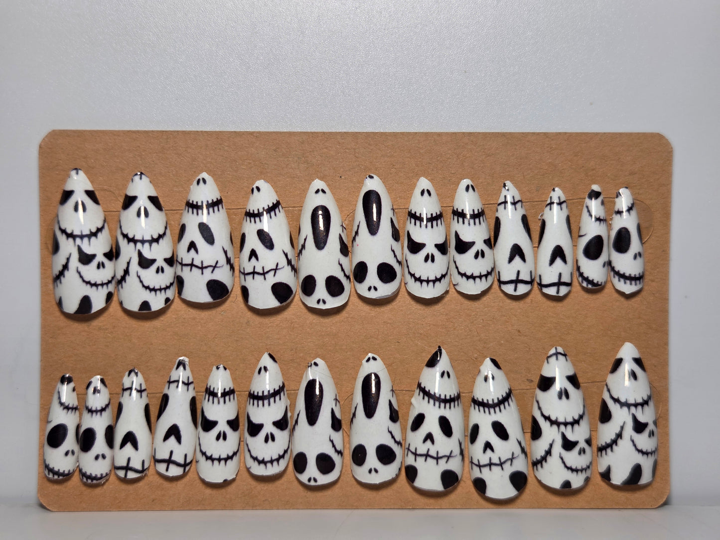 Set of Halloween-themed Glow in the Dark Press on Nails on a cardboard display against a plain background