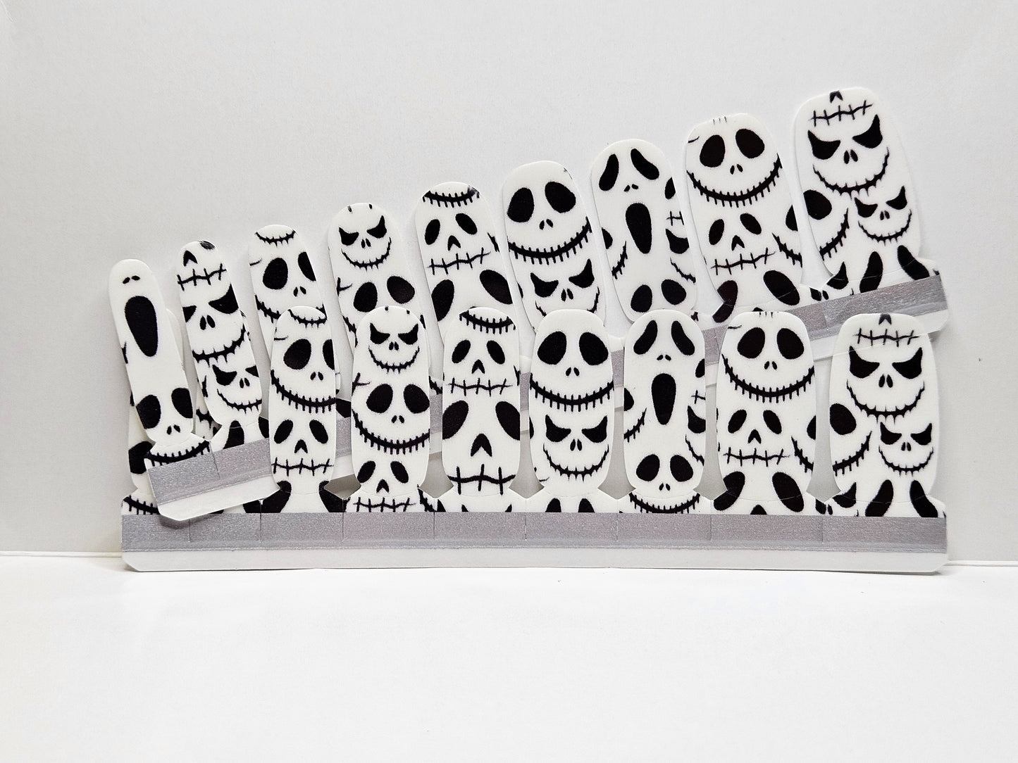Set of Halloween-themed face masks with skull designs Nail Wraps against a white background