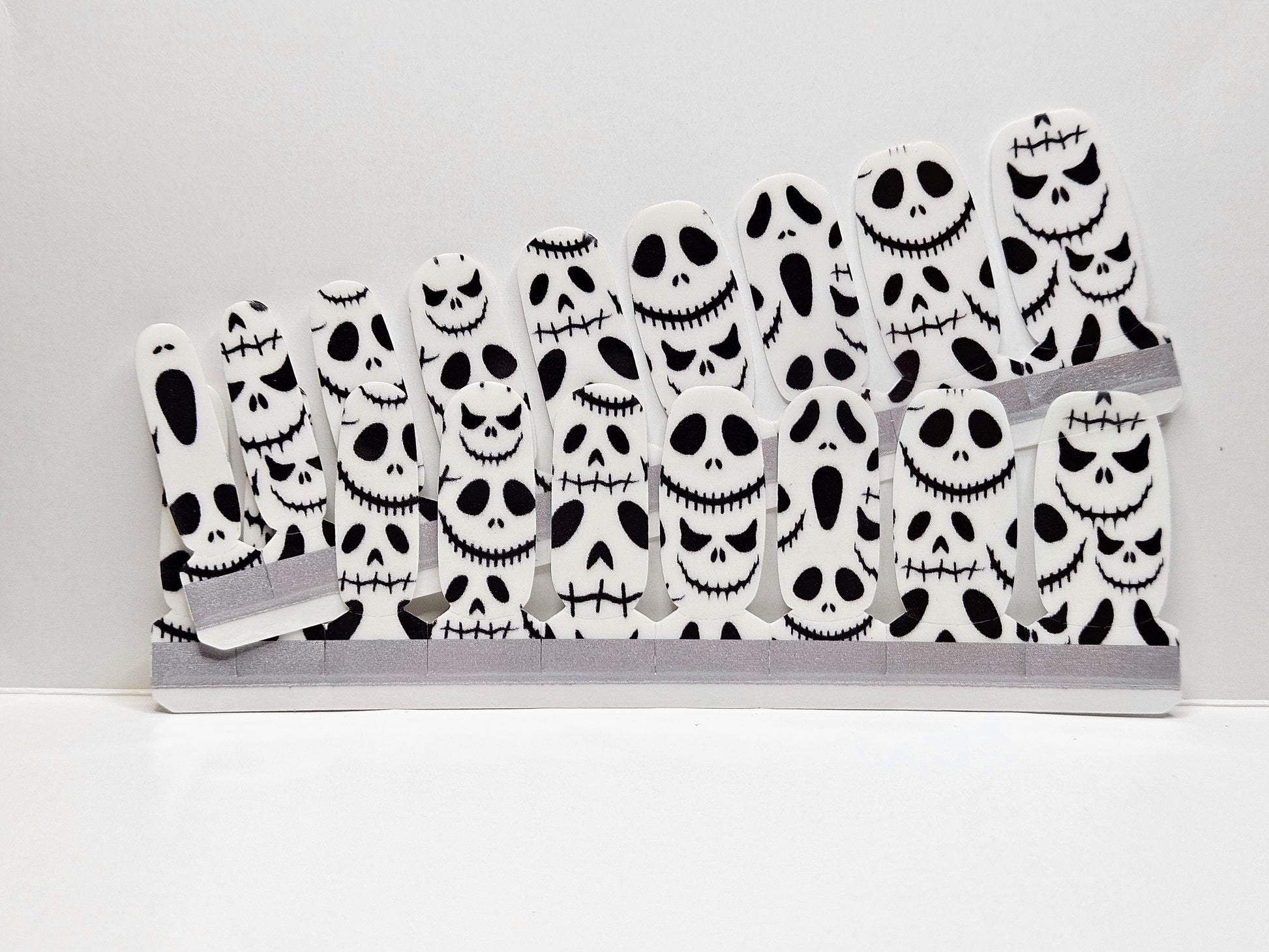 Set of Halloween-themed face masks with skull designs Nail Wraps against a white background