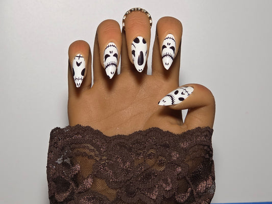 Hand with skull nail  on Glow in the Dark Nail Wraps against a plain background