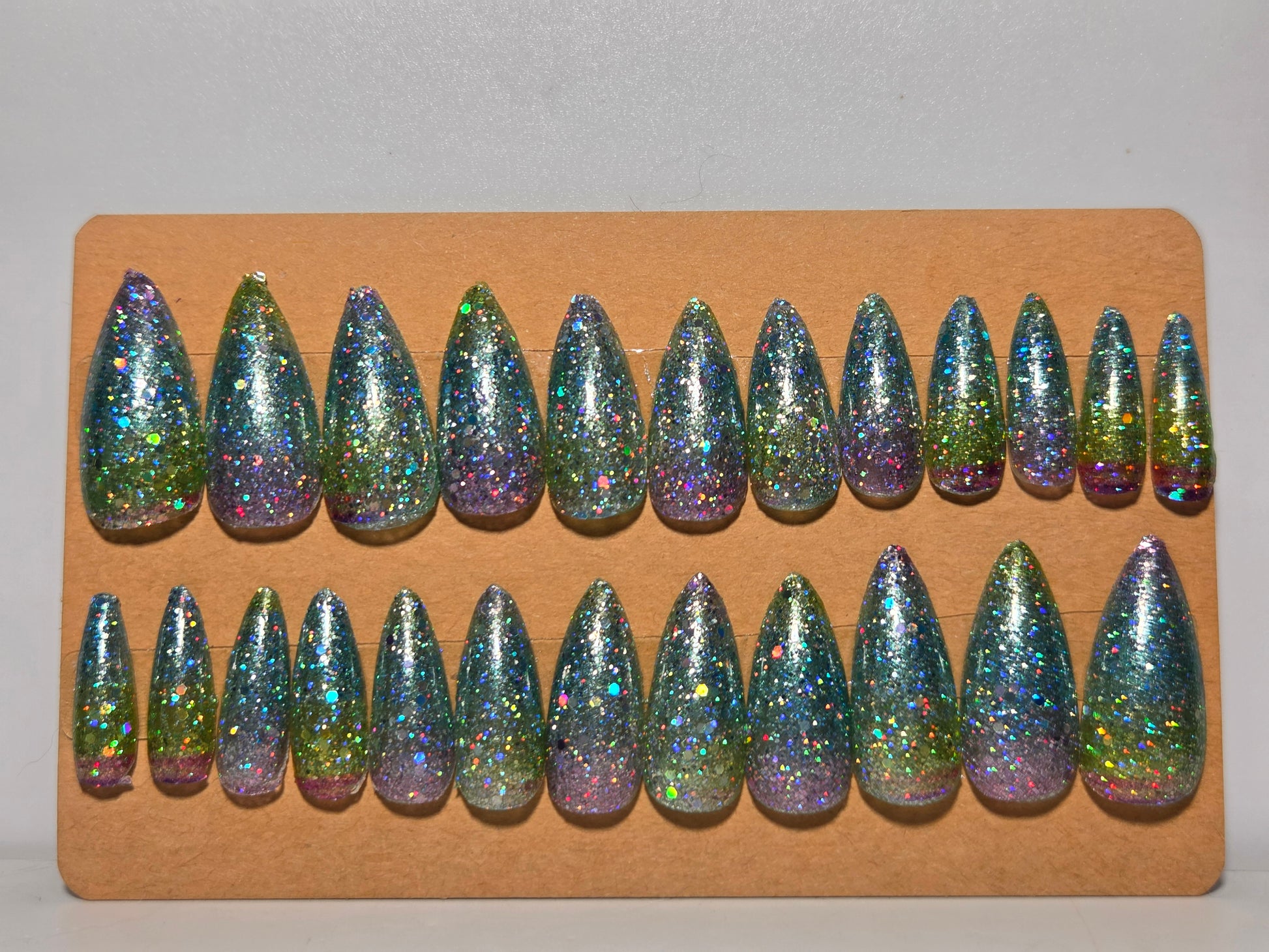 Set of glittery nail tips on a cardboard backing