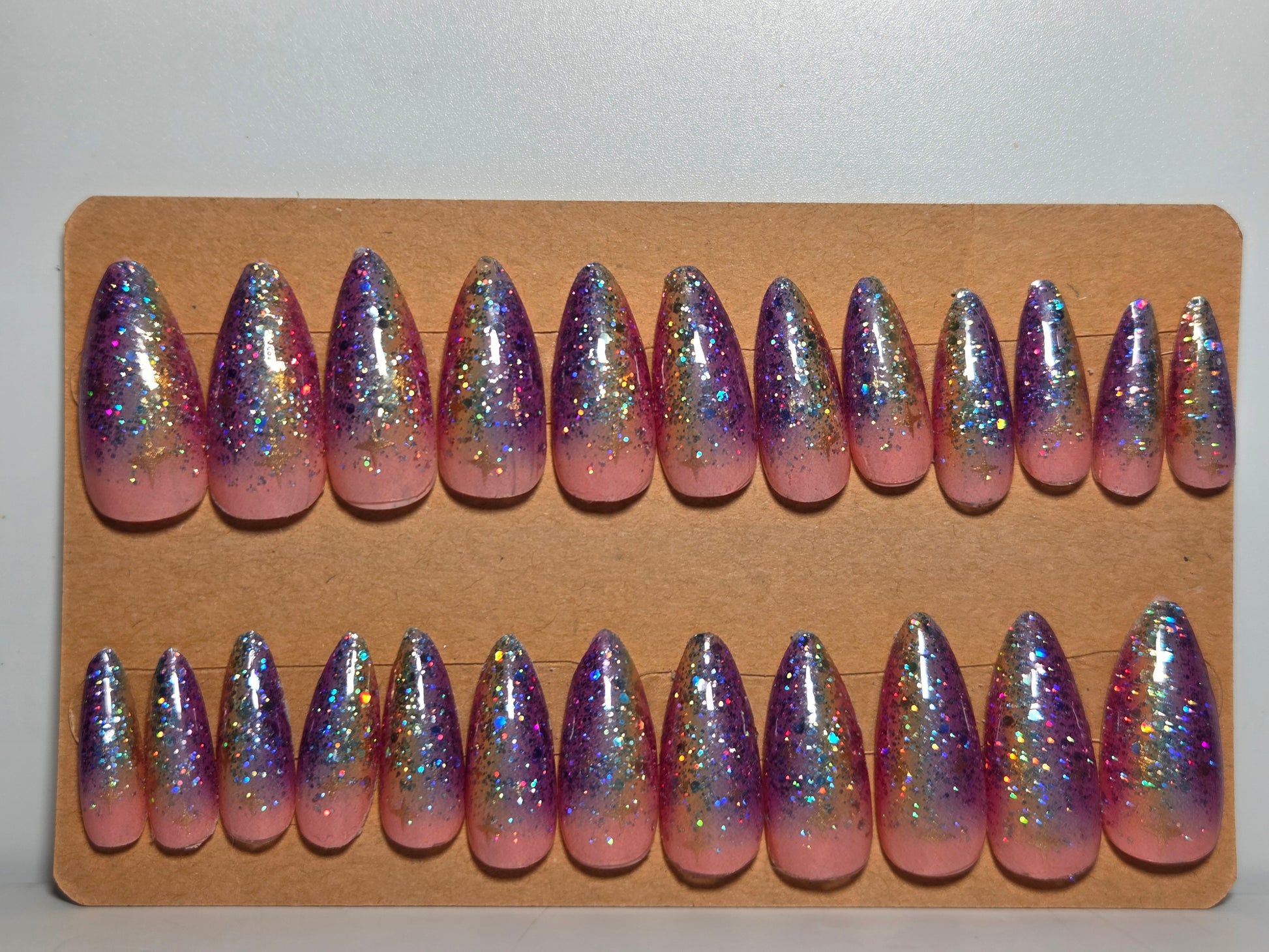 Set of pink and purple gradient handmade press on nails on a cardboard backing.